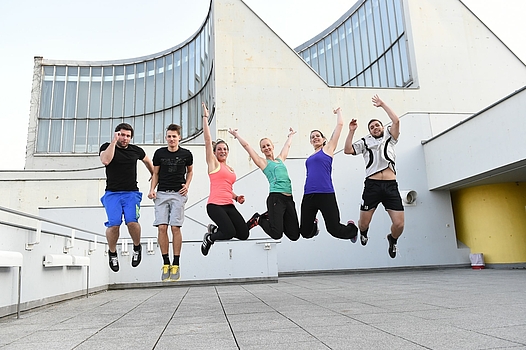 Students simultaneously jump into the air in front of the building ©Private Pädagogische Hochschule der Diözese Linz
