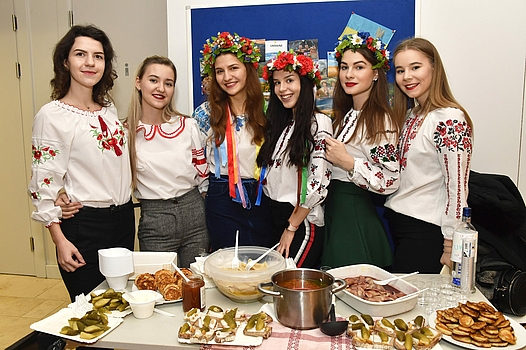 6 students - some with flower headdresses - smile into the camera in front of a trade fair stand ©FH OÖ