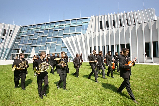 orchestra plays in front of the Anton Bruckner Privatuniversität © Reinhard Winkler