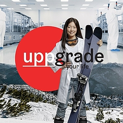 Young Asian woman in a doctor's coat and ski goggles around her neck holds skis in her hand ©Business Upper Austria