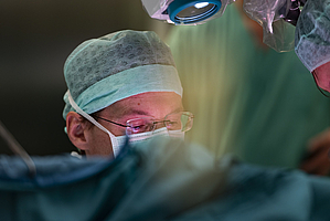 Doctor with glasses, face mask and protective cap operates in the operating room /The Photo was taken as part of FOTO CHALLENGE 2019, hosted by Upper Austrian Research © Elisabeth Mandl